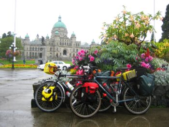 Touring bikes parked next to planter with famed Victoria landmark building in the background